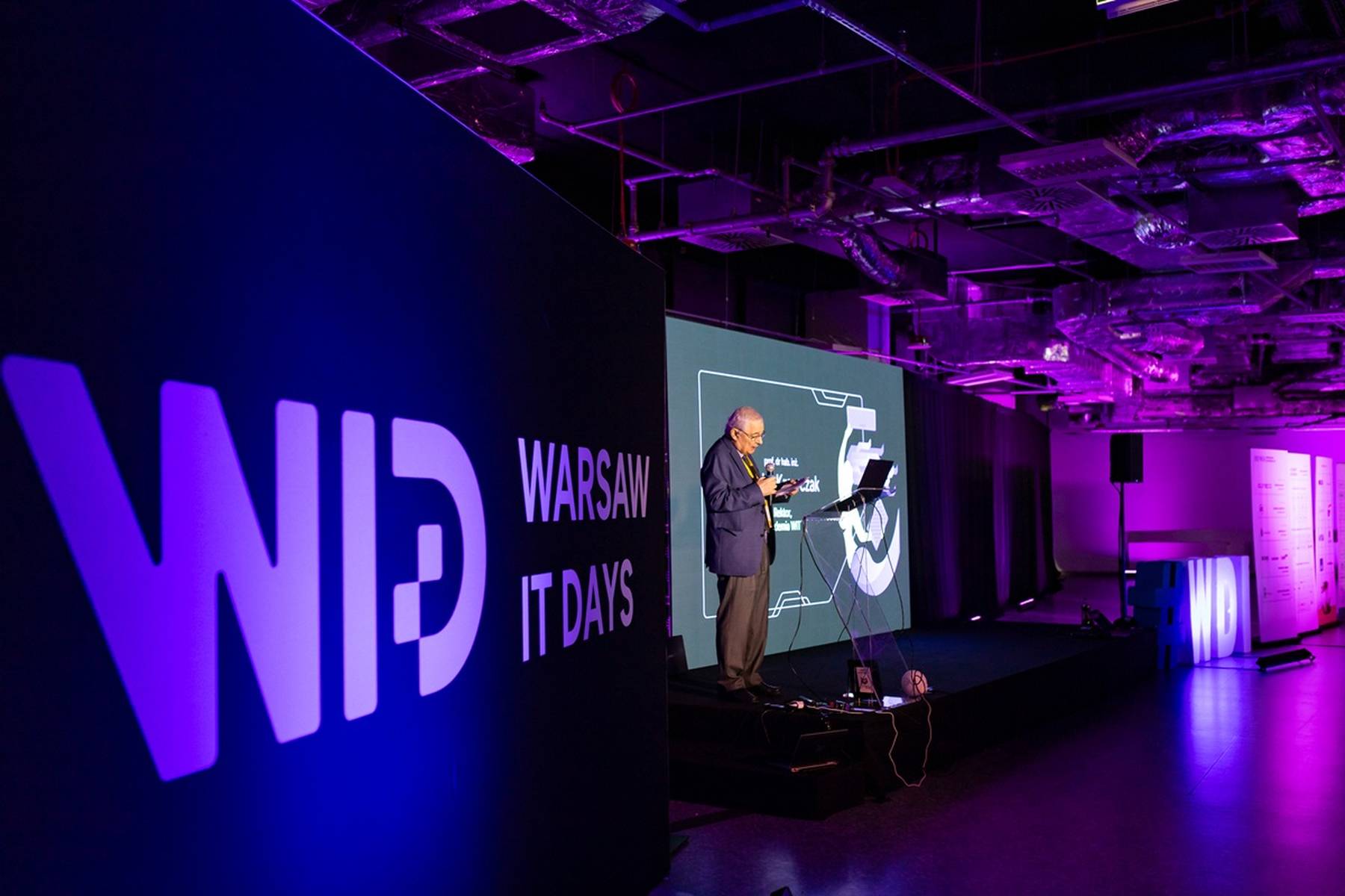 A speaker giving his presentation in front of a full house at the WDI